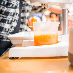 The orange juice shop on the street, which uses fresh oranges to make drinks, is very popular with the common people.