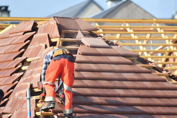 ouvrier couvreur sur un toit d'une construction - 778036988