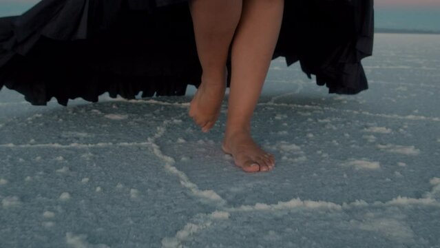 Feet of Redhead Woman with a mirror in Salt Flat in Bolivia