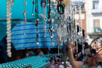 A woman is looking at a display of necklaces