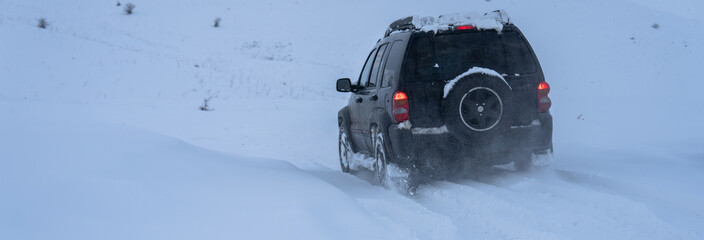An SUV drifting in a snow field