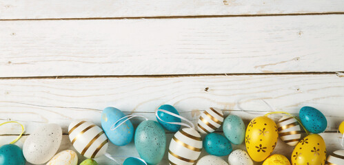 Happy easter banner. Colored Easter eggs on a wooden background. Copy space