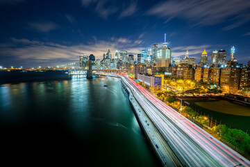 Panoramic view on Brooklyn Bridge with lower Manhattan skyline in New York City at night. 