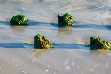 Seascape. Breakwater in the sun. Leba. Baltic Sea. Poland. - obrazy, fototapety, plakaty