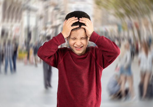 Front view of a child suffering social anxiety attack on city street