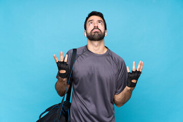 Young sport man with beard over isolated blue background frustrated by a bad situation