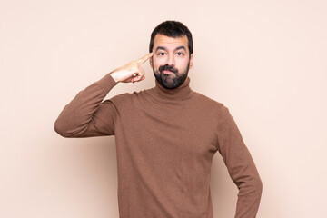 Man over isolated background making the gesture of madness putting finger on the head