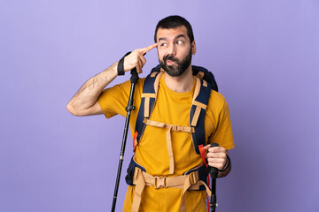 Caucasian handsome man with backpack and trekking poles over isolated background making the gesture of madness putting finger on the head