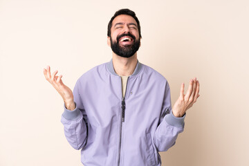 Caucasian man with beard wearing a jacket over isolated background smiling a lot