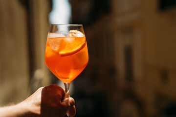 aperol spritz cocktail in female hand. Fresh and iced summer drink