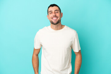 Young handsome caucasian man isolated on blue background laughing