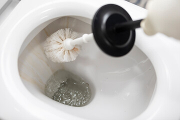 Сlose-up shot of a housewife in rubber gloves cleaning a toilet using a special cleaning product and a brush	