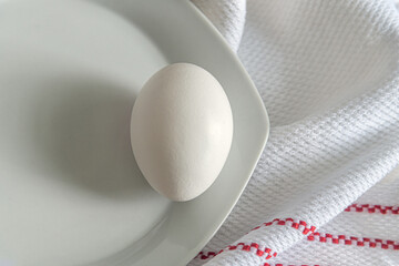 chicken egg on white plate top view