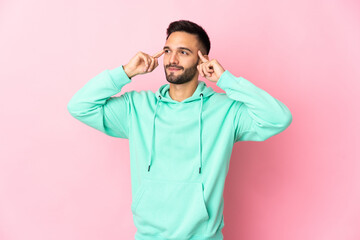 Young caucasian man isolated on pink background having doubts and thinking