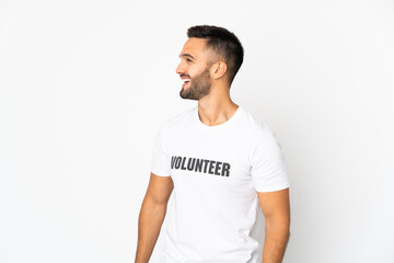 Young caucasian volunteer man isolated on white background looking side
