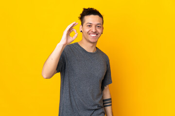 Caucasian man over isolated background showing ok sign with fingers