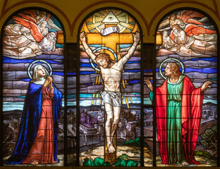MILAN, ITALY - MARCH 4, 2024: The Calvary in the stained glass in the church Chiesa di San Agostino from year (1950).