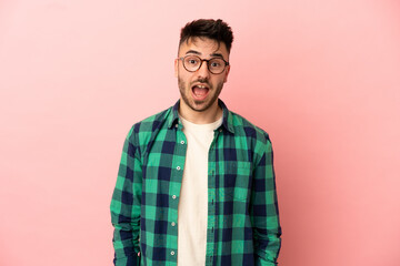 Young caucasian man isolated on pink background with surprise facial expression
