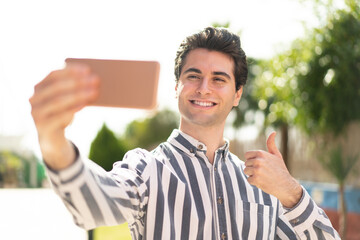 Young handsome man making a selfie with mobile phone