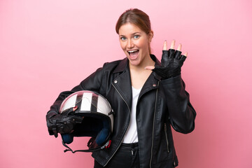 Naklejka premium Young caucasian woman with a motorcycle helmet isolated on pink background counting five with fingers