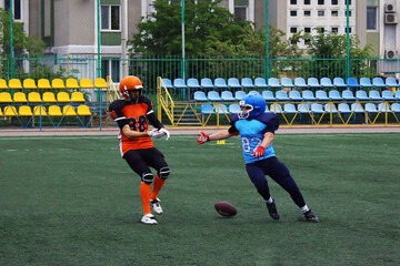 American football player knocks the ball out of his opponent's hands	

