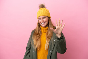 Young blonde woman wearing winter jacket isolated on pink background counting five with fingers