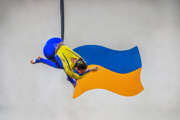 Aerial gymnast against the background of the Ukrainian flag