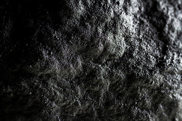 Extreme close up of painted in black handmade paper mache with a structure and rough texture.