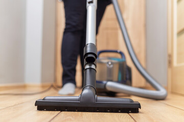 Person vacuuming floor. Household chore and cleaning concept.