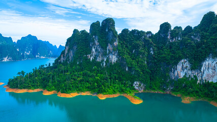 The green area at Khao Sok national park Cheow Lan Dam lake with blue sky background in Surat Thani, Thailand.