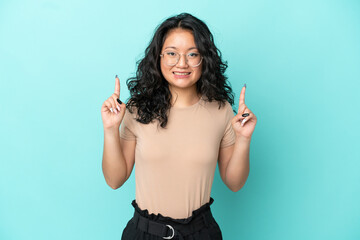 Young asian woman isolated on blue background pointing up a great idea