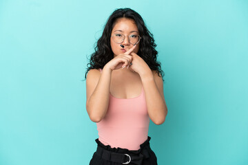 Young asian woman isolated on blue background showing a sign of silence gesture