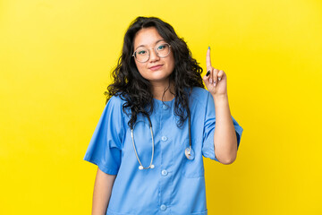 Young surgeon doctor asian woman isolated on yellow background pointing with the index finger a...