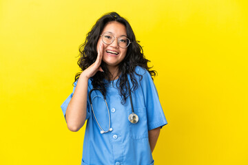 Young surgeon doctor asian woman isolated on yellow background with surprise and shocked facial...