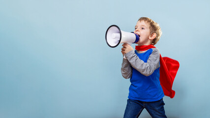 Child in superhero costume shouting into megaphone against blue background