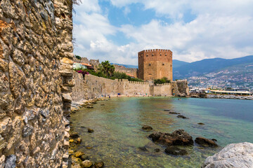 Historic Alanya castle walls by the clear turquoise sea, a blend of natural beauty and ancient...