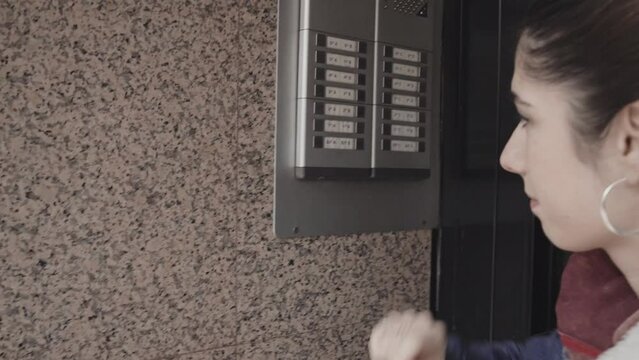 Close up of woman ringing the doorbell of a house