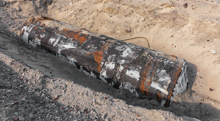 weathered underground oil tank lies dug out lies on the sand