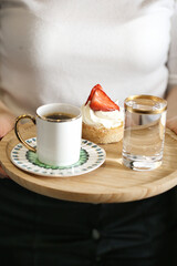 Fototapeta na wymiar Person Holding Tray With Coffee Cup and Strawberry