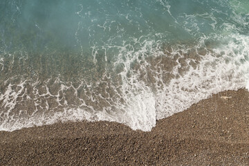 Mediterranean sea waves on a pebble beach on a sunny day - 778171913