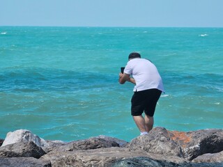 Capturing Memories: Man Photographing the Sea