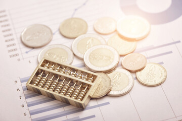 Coins and abacus placed on financial data reports