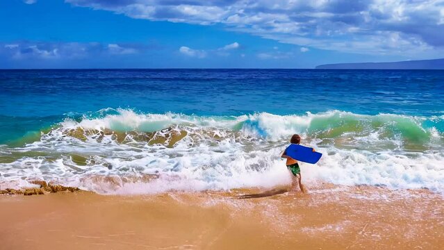 Young boy runs on sand making bodyboarding, Big Beach, Maui in Hawaii, America.