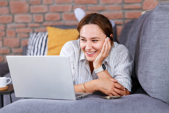 Young woman using laptop on sofa