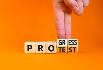 Progress vs protest symbol. Concept word Progress Protest on beautiful wooden cubes. Beautiful orange table orange background. Businessman hand. Business progress vs protest concept. Copy space.