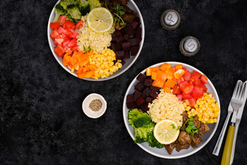 Bowl dish with fried turkey liver, bulgur, beet, pepper, tomato, broccoli, sweet corn, lemon. Healthy balanced eating. Top view