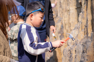A boy search for fossils in a shale outcroppping at the foot of the hill