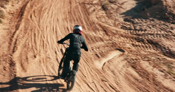 Biker, motorbike and man in air or outdoor training for extreme sports, safety and practice on sand. Sky, off road or fearless driver jumping with motorcycle trick for race or cycling in challenge