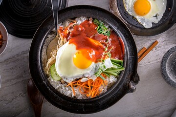 Sizzling Bi Bim Bap: 4K Ultra HD Top View, Mixed Vegetables, Rice, and Hot Sauce in Cast Iron Pot