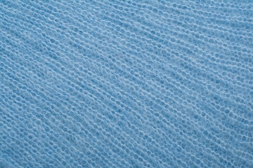 Sweater or scarf fabric texture large knitting. Knitted jersey background with a relief pattern. Wool hand- machine, handmade, blue.